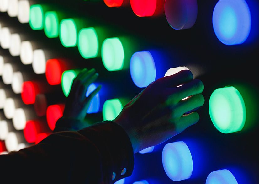 Hands touching colorful lights